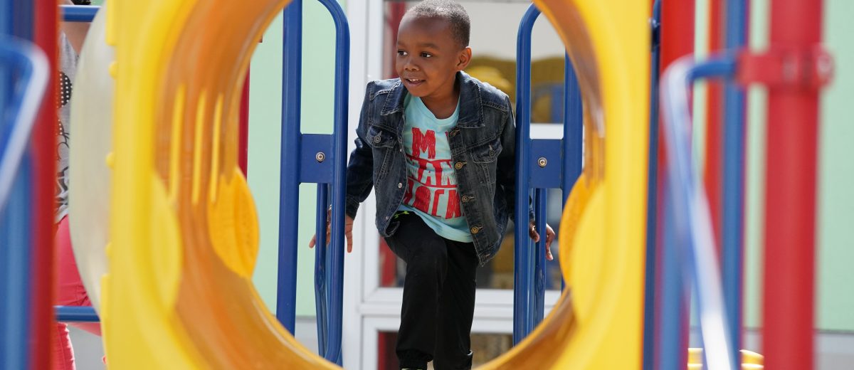 photo of young child outside playing on playground equipment