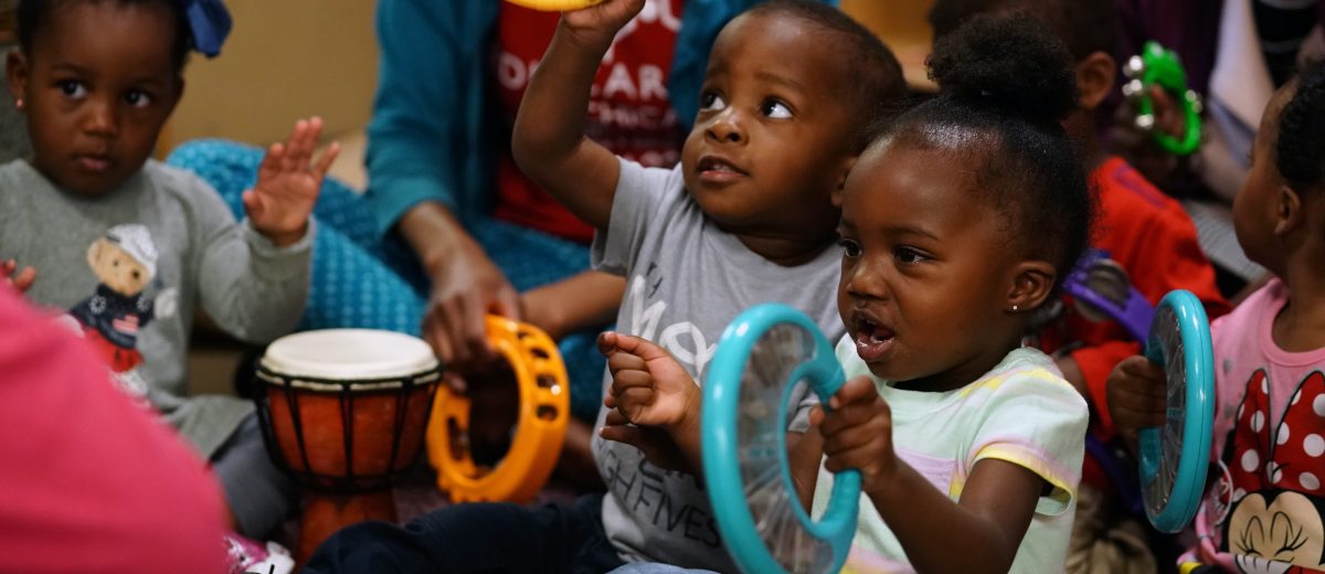 photo of young children playing musical instruments