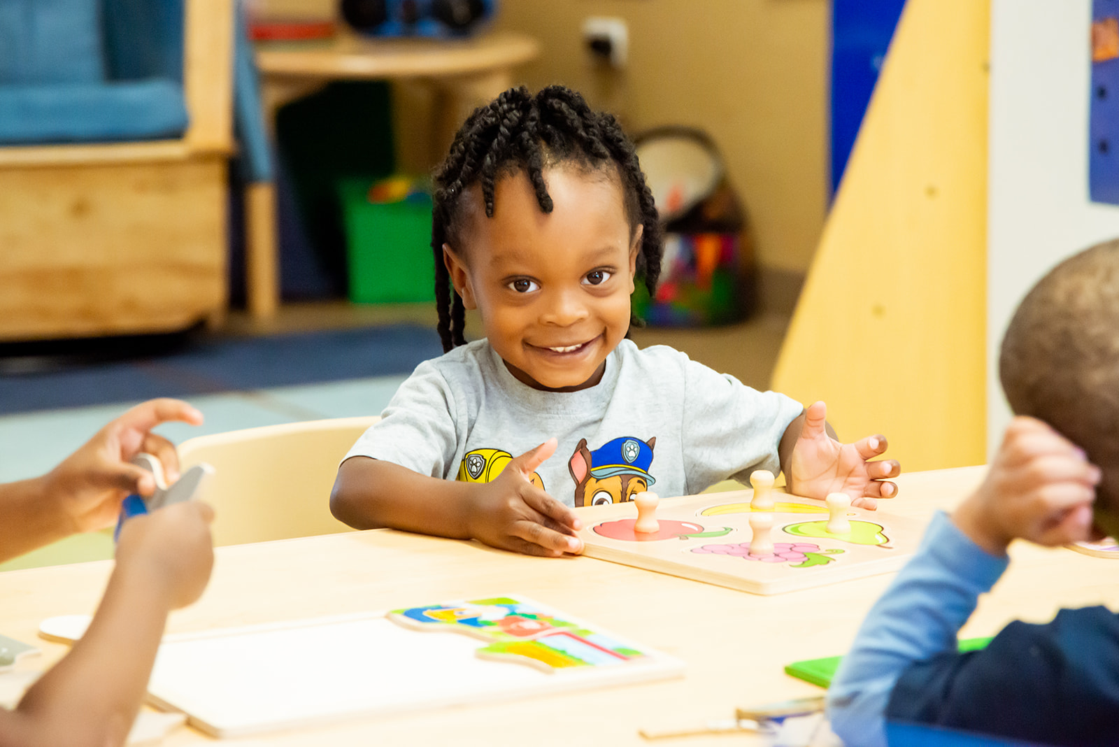 Child smiling doing a puzzle.