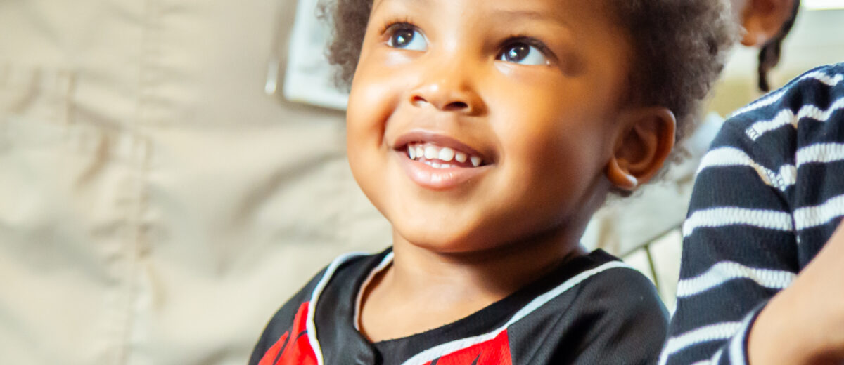 toddler wearing jersey smiling
