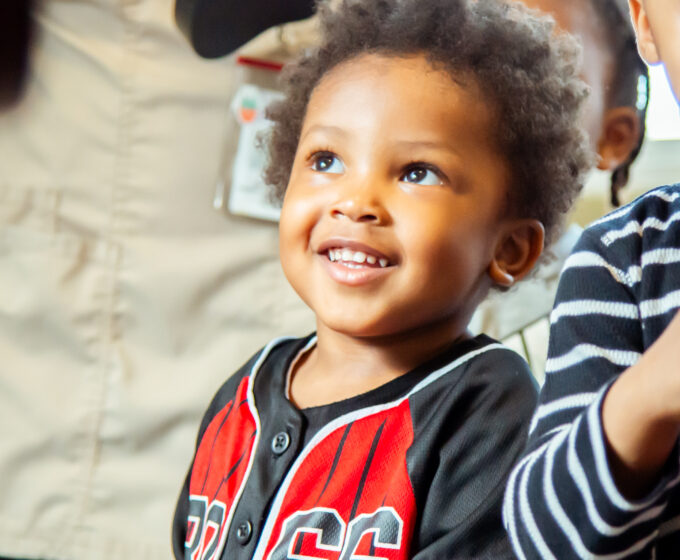 toddler wearing jersey smiling