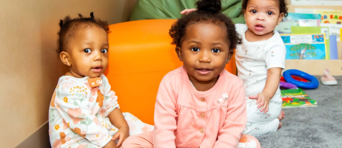 Three children sitting in play corner