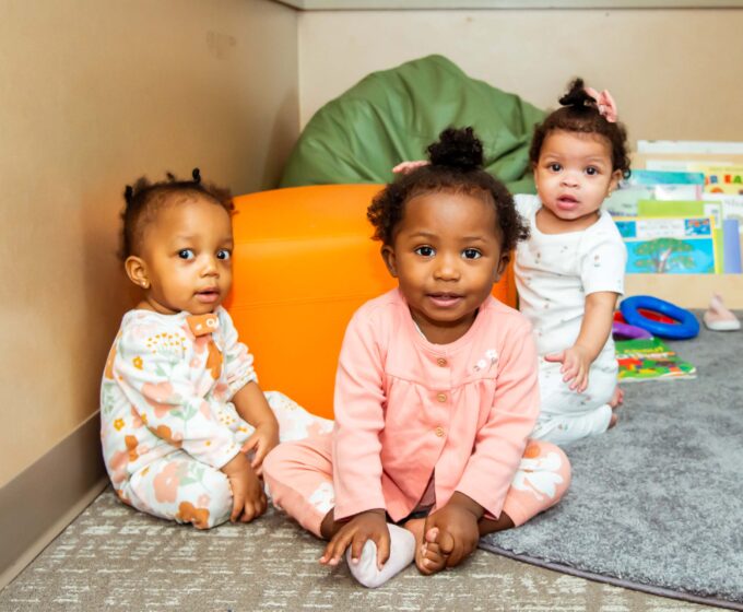 Three children sitting in play corner